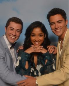 two men and a woman are posing for a photo with their arms around each other