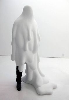 a man standing next to a white sculpture