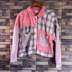 a pink shirt hanging on a wooden wall