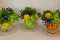 three small vases with plants in them