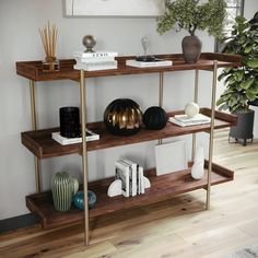 a shelf with books, vases and other items on it in a living room