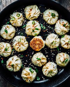 a pan filled with dumplings covered in sauce and seasoning sprinkled on top