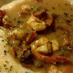 shrimp and grits in gravy on top of mashed potatoes with garnish