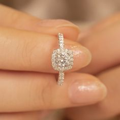 a person holding a diamond ring in their hand