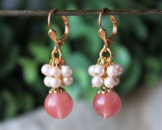 "This lovely pair of earrings features a beveled-cut cherry quartz, which are accented with an ornate pewter bead cap, plated in 24 karat gold. This striking color combination is offset with beautiful clusters of champagne freshwater pearls. Hanging from a surgical steel lever-back, it measures 1 ¼\" in length. Earrings are light weight and sway gracefully as you move about your day. These stunning dangle earrings are unique, feminine and eye-catching, a great accent to any wardrobe. Also availa Cluster Earring, Pearl Rose, 24 Karat Gold, Jewelry Knots, Silver Dangle Earrings, Quartz Cluster, Earrings Drop, Pink Gifts, Cluster Earrings