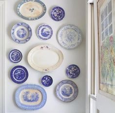 blue and white plates are hanging on the wall