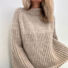 a blonde woman with long hair wearing a sweater