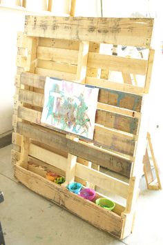 a wooden pallet filled with lots of different types of paint and toys on top of it