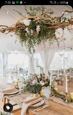 a wedding reception setup with white flowers and greenery