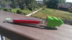 two green and red scissors sitting on top of a wooden table next to each other