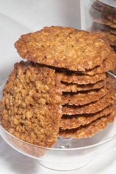 a stack of oatmeal cookies sitting on top of a glass plate next to a container