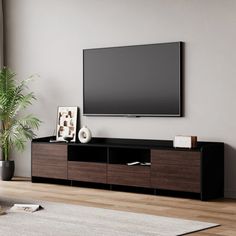 a large flat screen tv mounted to the side of a wooden entertainment center in a living room