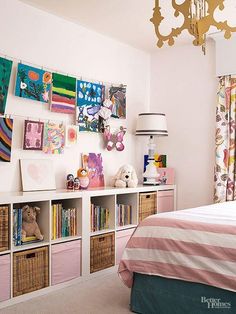 a bedroom decorated in pink and white with pictures on the wall