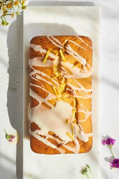 a white plate topped with a cake covered in icing and lemon zeurd