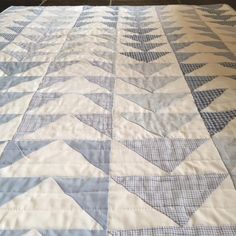 a quilted bed spread with white and blue designs