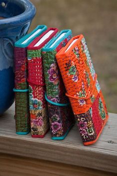 a blue vase sitting on top of a wooden table next to colorfully colored books