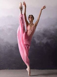 a woman in a pink dress is dancing with her arms up and legs spread out