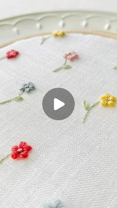 the video is showing how to make an embroidered flower design on a piece of fabric