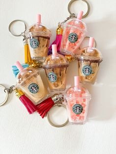 starbucks keychains are arranged in the shape of bottles with tassels on them