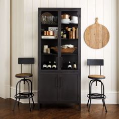 two chairs and a cabinet in a room with white walls, wood floors and wooden flooring