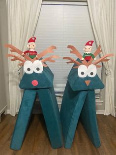 two children's toys are sitting on top of the legs of these reindeers