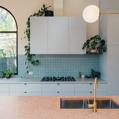 a kitchen with an oven, sink and window in the backround is shown