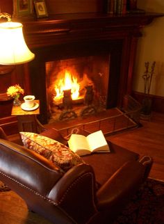 a living room filled with furniture and a fire place next to a lamp on top of a table