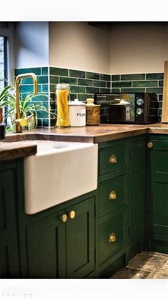 a kitchen with green cabinets and white sink