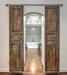 an open wooden door leading to a bathroom