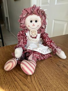 a stuffed doll sitting on top of a wooden table