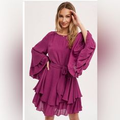 Long Layered Bell Sleeve Dress Ties Around The Waist Lined Color/ Magenta 100% Polyester Purple Dress With Ruffle Hem For Day Out, Purple Dresses With Ruffle Hem For Day Out, Purple Dresses For Day Out In Fall, Purple Dress For Day Out In Fall, Purple Ruffle Hem Dress For Brunch, Flowy Tiered Dress For Brunch, Purple Dress For Fall Brunch, Fall Day Out Purple Dress, Fall Brunch Purple Dress