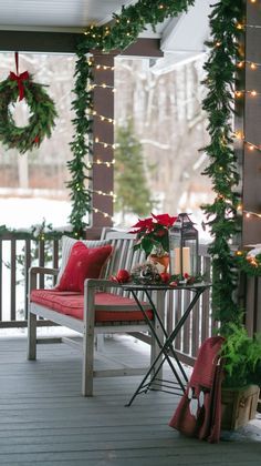 a porch decorated for christmas with wreaths and lights