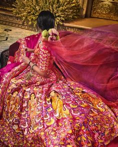 a woman sitting on the ground in a colorful dress