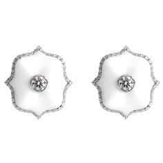 A pair of platinum Mini Lotus ear clips each centered upon a round brilliant-cut colorless diamond set in matte white ceramic with a colorless diamond micropavé surround. Luxury White Diamond Platinum Earrings, Luxury White Platinum Diamond Earrings, Exquisite White Diamond Earrings For Evening, Luxury White Earrings With Single Cut Diamonds, White Luxury Earrings With Single Cut Diamonds, Luxury White Diamond Earrings For Formal Occasions, Luxury Diamond White Earrings With Pave Setting, Timeless White Earrings With Diamond Accents, Luxury Diamond White Earrings With Diamond Accents