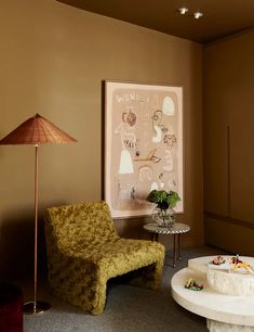 a living room filled with furniture and a painting hanging on the wall above a table