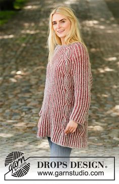 a woman standing in the middle of a road wearing a red and white striped sweater