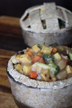 two bowls filled with food sitting on top of a wooden table