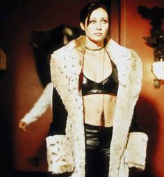 a woman in a leather bra top and fur vest