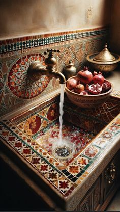 a bowl of pomegranates sits on top of a sink with water running from the faucet