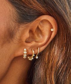 An everyday essential with glittering flair. This miniature huggie earring is crafted with a row of sparkling pavé diamonds and accented with a single bezel-cut drop diamond that hangs delicately off the ear. It features 0.14 carats of diamond set in your choice of gleaming 14k yellow, rose, or white gold. Bezel drop measures: 3mm Diameter of mini huggie: 9.5mm Gold Diamond Huggie Earrings, Fine Jewelry Huggie Earrings With Bezel Setting, 14k Gold Huggie Jewelry With Bezel Setting, Diamond Drop Earrings With Bezel Setting, Diamond Ear Piercings, Ear Aesthetic, Earring Huggies, Jewellery Design Ideas, Double Ear Piercings