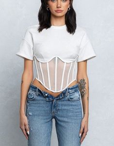 Elevate your tee game with the Eboni Mesh Bustier T-shirt, complete with unique mesh detailing and playful boning. This is no ordinary t-shirt - it's a statement piece for those who don't take themselves too seriously. PRE-ORDER - Mesh bustier boning detail terry short sleeve top - Short sleeve crewneck top - Full back zipper closure - French terry part has semi stretch - Mesh part has good stretch - Model size 5' 9" ( Wearing S size) Night Out Tops, Activewear Fashion, Mesh Sleeves, Bustier Top, Curve Dresses, Good Stretches, Club Dresses, Short Sleeve Top, Outerwear Jackets