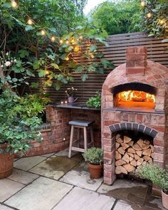 an outdoor pizza oven with firewood in it and potted plants on the side