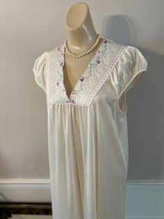 "Very sweet retro night gown from Movie Star in excellent condition. Size is M. My dress form is a Small and I think a lady who wears either a S or M in a dress can wear this night gown. Color is a creamy beige and silky nylon fabric has a pretty drape and flow. Adorable detail at the neckline and shoulders. On either side of the V neckline and just below the bottom of the V is a bit of softly quilted fabric with tiny embroidered flowers. The inside edge of the V is scalloped and along the outsi Feminine Cream Nightgown With Lace Trim, Vintage Cream Nightgown For Bedtime, Cream Vintage Nightgown For Bedtime, Cream Nightgown With Lace Trim For Bedtime, Vintage Cream Nightgown For Sleep, Vintage Cream Nightgown For Loungewear, Vintage Cream Nightgown, Beige V-neck Nightgown For Sleep, Beige Nightgown For Wedding Night