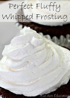 a chocolate cupcake with white frosting on top and the title overlay reads perfect fluffy whipped frosting