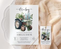 a baby shower with a tractor and greenery on it, next to a tag