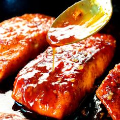 a spoon drizzling ketchup onto some meat