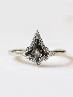 Why You'll Love It A geometric bold beauty. This ring features a salt & pepper kite diamond with a handcrafted halo setting that makes this a one-of-a-kind black diamond engagement ring. Pair this enchanting ring with our Kite Halo Matching band to complete the set. Details 14K solid gold Band width is approx. 1.60mm Salt & pepper kite diamond x 1 piece (0.7~0.9ct) Size of gem may vary based on our selection for all non-custom engagement rings. SI/G 1mm Diamond x 20~30 pieces (0.09ct) SI/G 1.5mm Kite Diamond, Halo Band, Black Diamond Engagement Ring, Future Engagement Rings, Black Diamond Engagement, Solid Gold Band, Black Diamond Ring Engagement, Halo Setting, Dream Engagement Rings