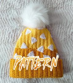 a knitted beanie hat with white and yellow triangles on it that says pattern