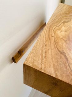 a close up of a wooden table with a white wall in the background