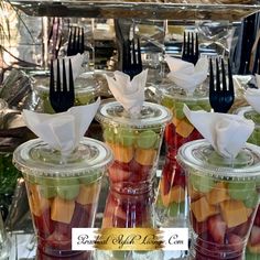 there are many different types of fruit in plastic cups with forks on the top and bottom